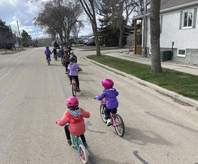 Children bicycle in street as part of a Bike Bus in Camrose, Canada