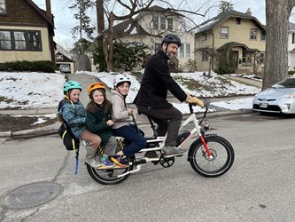 Sam Rockwell with his kids, Teddy, Maggie, and Frankie, travel by e-bike in Minnesota