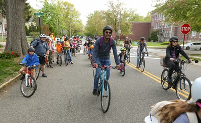 Adults and kids travel through intersection together in a bike bus